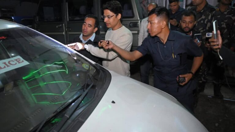 MP Raju Bista showing the broken glass of a car part